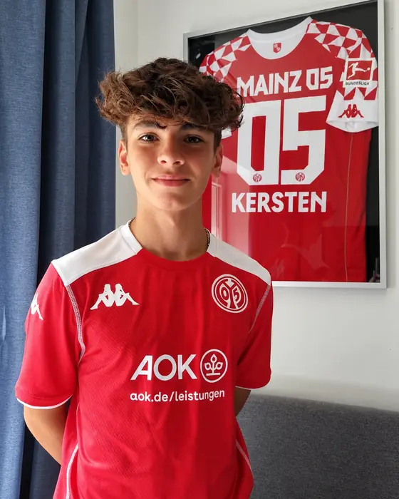 Alessio Kersten im Trikot des 1. FSV Mainz 05, dahinter sein gerahmtes Mainzer Trikot